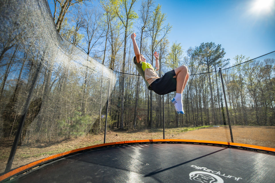 A kid doing a backflip on a Jumpzylla Trampoline.